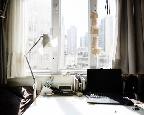 A desk setup positioned perpendicular to a window with soft daylight