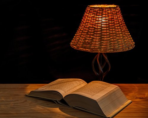 Cozy reading corner with a warm desk lamp lighting a book