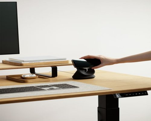 A person adjusting monitor distance at a modern office desk